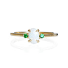 A product photo of a delicate 9ct yellow gold 6x4mm white opal and tsavorite trio ring sitting on a white background. The fiery opal centre stone is hugged on either side by a bright green tsavorite jewel.