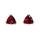 A product photo of 9ct yellow gold garnet stud earrings sitting on a white background. The trilliant stones are held in place by two claws on each corner, to a total of 6. The deep red garnet stones reflect sanguine light from their many edges.