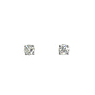 A product photo of a pair of 9 karat white gold lab diamond stud earrings sitting in the sun on a white textured background. The brilliant, colourless half pointer round diamonds measure approximately 3.5mm across, and are held in place by a simple 4-claw setting.