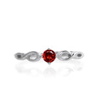 A product photo of an ornate silver ring with a garnet centre stone sitting on a white background. The silver band splits halfway along its length, becoming twisting and serpentine in appearance before meeting on either side of the dazzling red 3.5mm stone, which is held in place by 4 silver claws. The deep red gemstone colour would be a good ruby alternative.