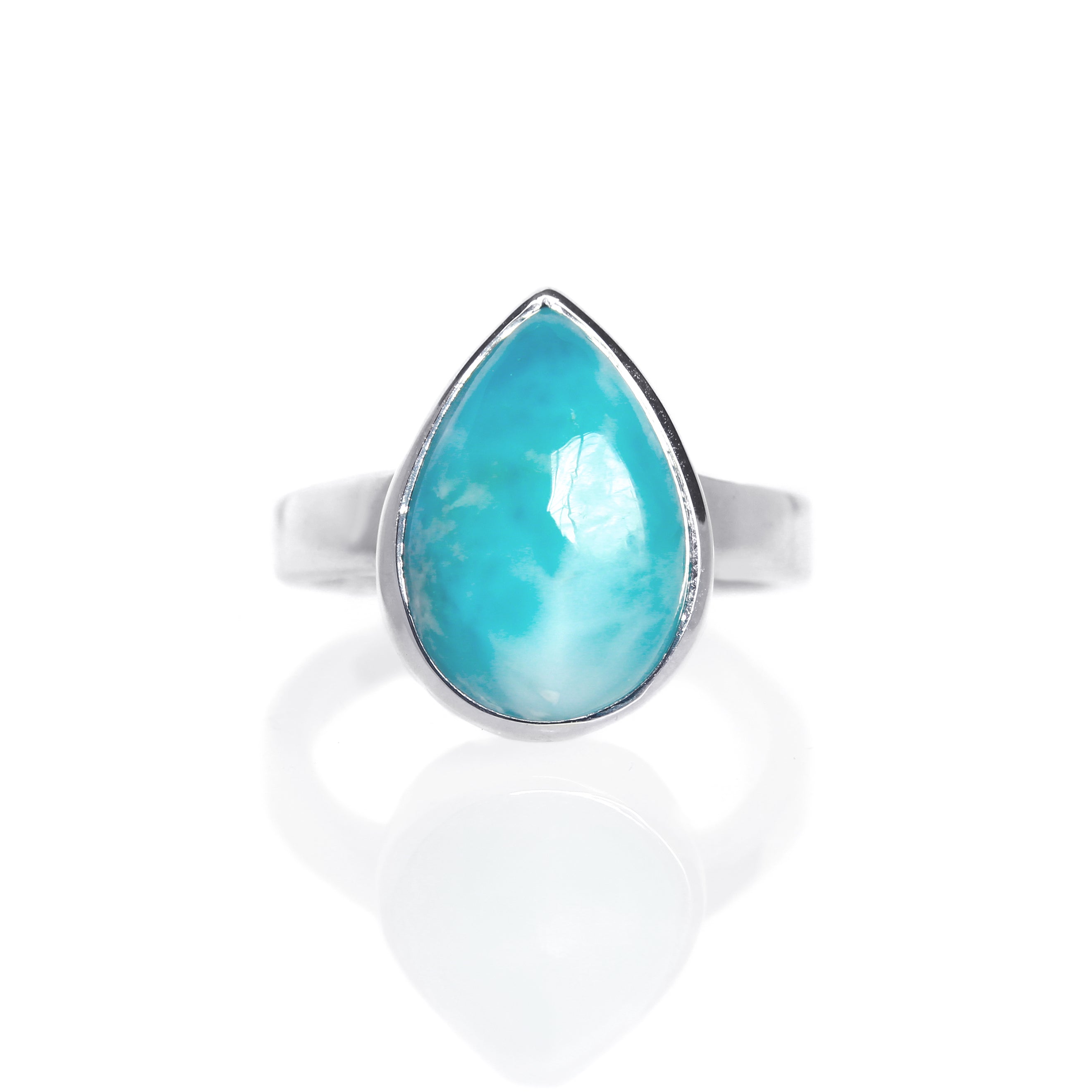 A product photo of a silver Larimar ring on a white background. The band is tall and thick. The 12x8mm pear cabochon Larimar stone has dappled white and light blue patterning, similar to water reflections at the bottom of a pool. The stone is set in a thick silver bezel setting.