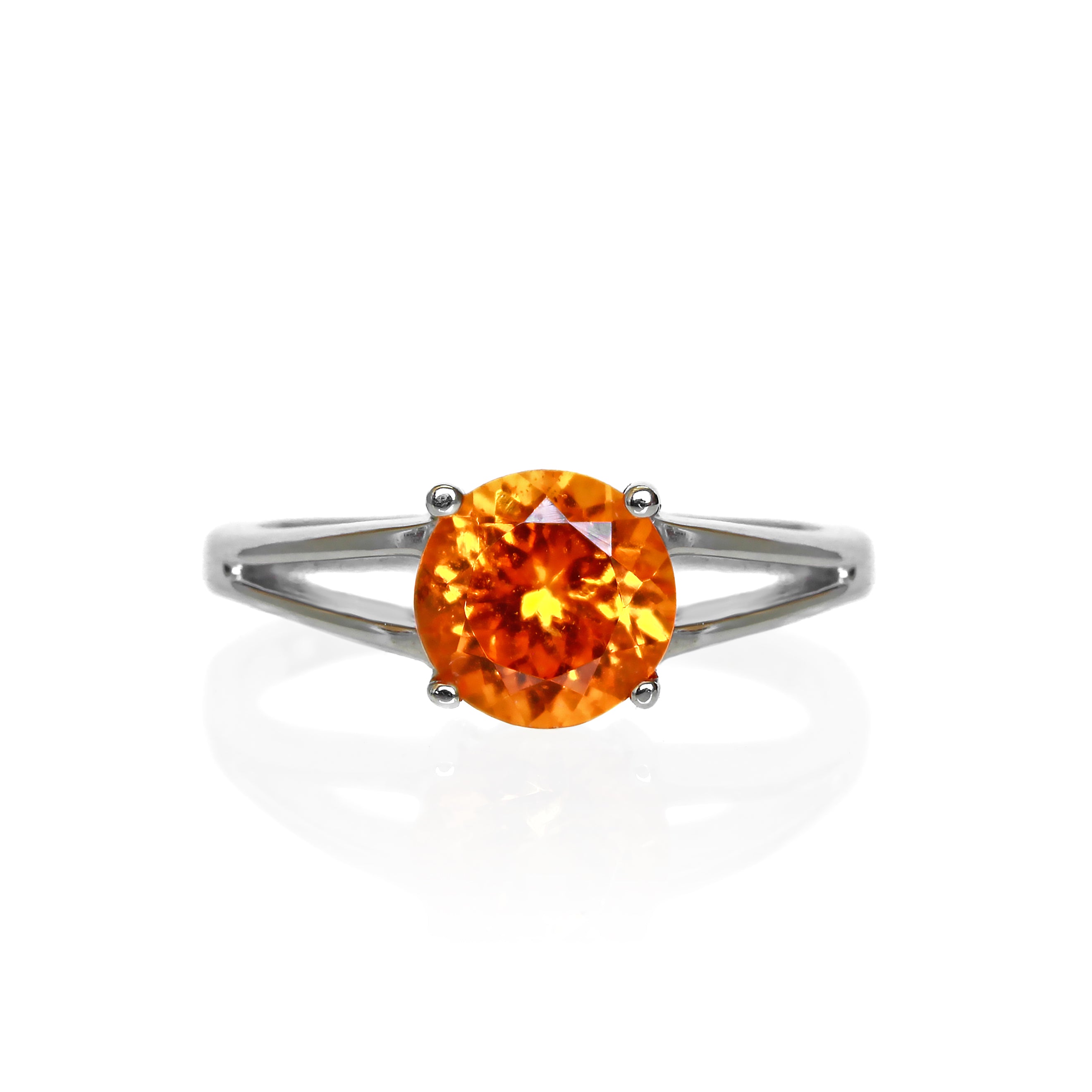 A product photo of an orange mandarin garnet solitaire ring in solid 9 karat white gold on a white background. The band is split into two prongs, meeting on either side of the 7mm round faceted orange garnet jewel.