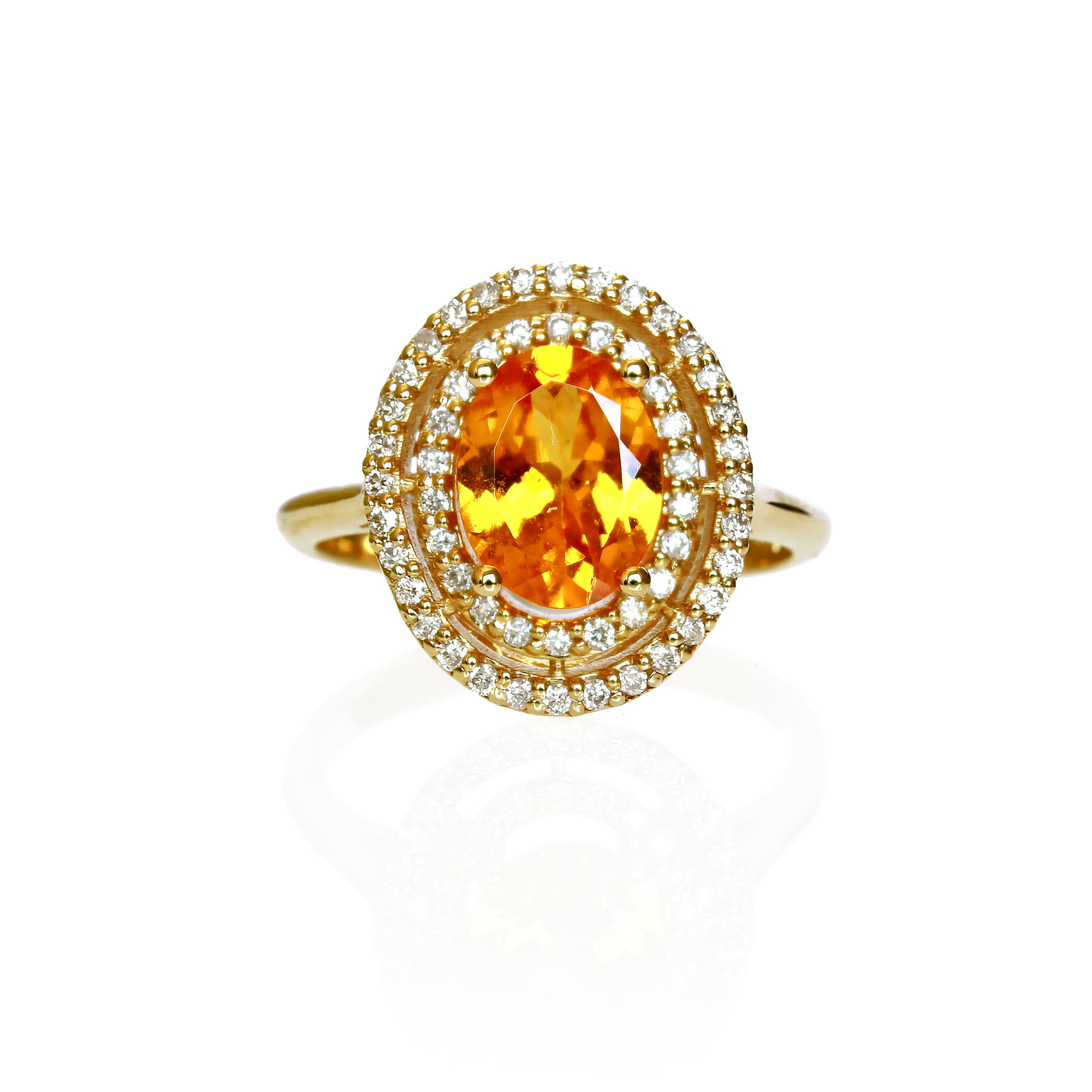 A product photo of an elaborate orange mandarin garnet and diamond engagement ring in solid 14 karat yellow gold on a white background. The ring is composed of a large electric orange garnet stone, surrounded by a double halo of diamonds (54 total) and held in place by ornate golden detailing.