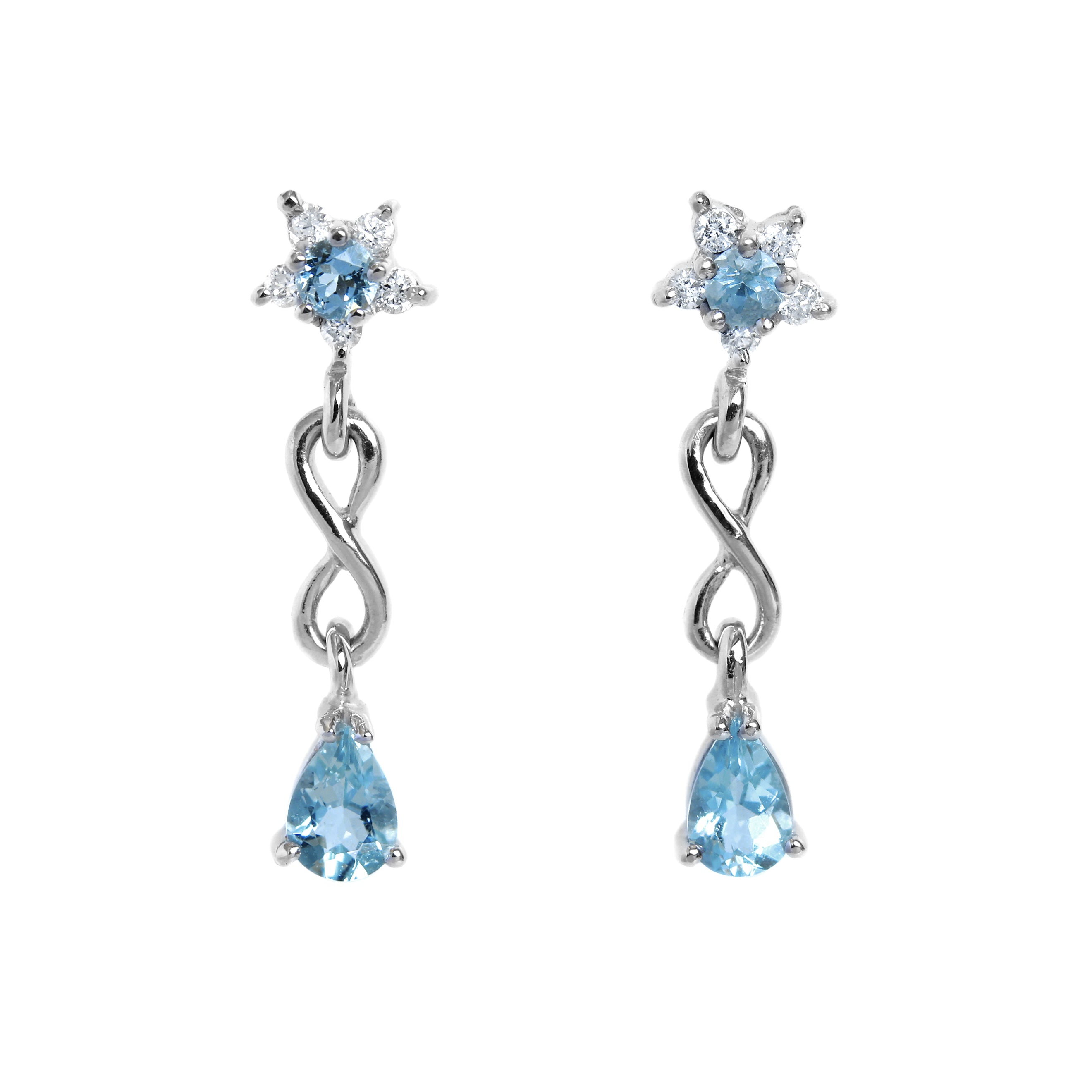 A product photo of a pair of aquamarine stud drop earrings in 9k white gold over a white background. The earrings are composed of a thick frame of white gold in the shape of a tear, swooping downwards to meet on either side of a gold-encased round aquamarine gemstone. Where the frame and bezel-setting meet are 3 dainty detailing diamonds on either side.