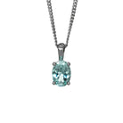 A product photo of a silver aquamarine pendant suspended by a silver chain against a white background. The oval gemstone is held in place by 4 small claws, and reflects deep baby blue hues from its many edges