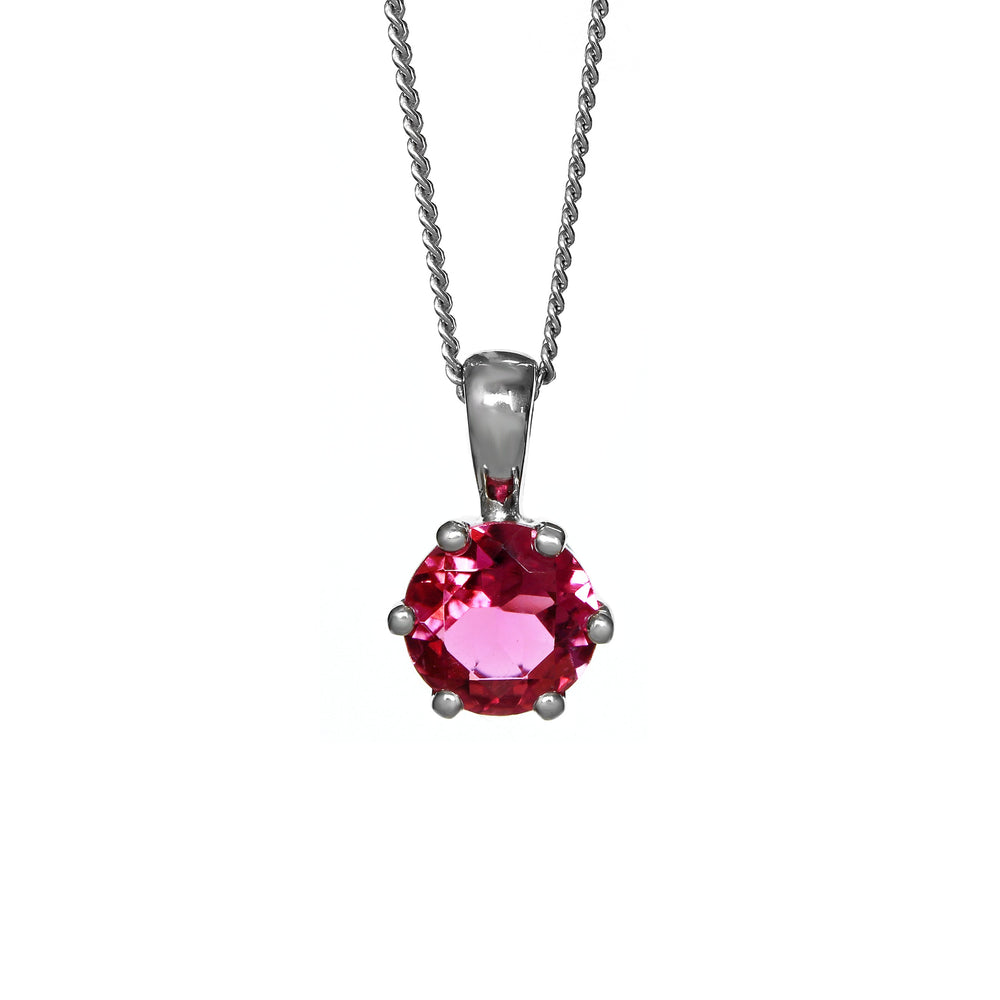 A product photo of a silver pink tourmaline pendant against a white background. The highly-reflective round cut pink tourmaline stone is held in place by 6 dainty silver claws. It is suspended by a simple silver chain.