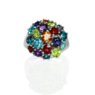 A product photo of an unconventional statement ring, featuring a basket of birthstone jewels arranged in a circular pattern of varying sizes.