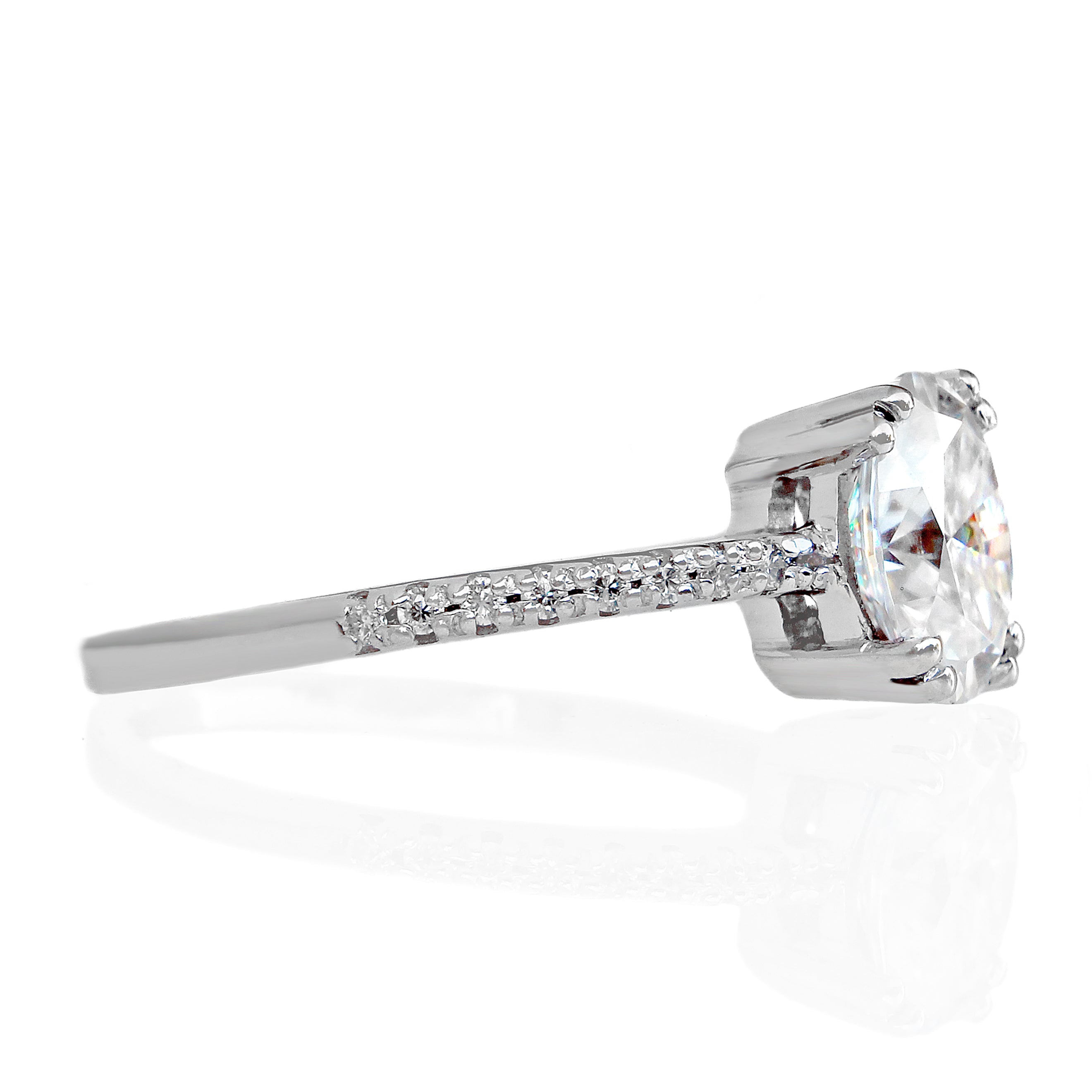 A product photo of a silver moissanite engagement ring on a white background. The ring styles an 8x6mm moissanite centre stone, with a callback to the pavé engagement styles of the past with its moissanite-embedded band.