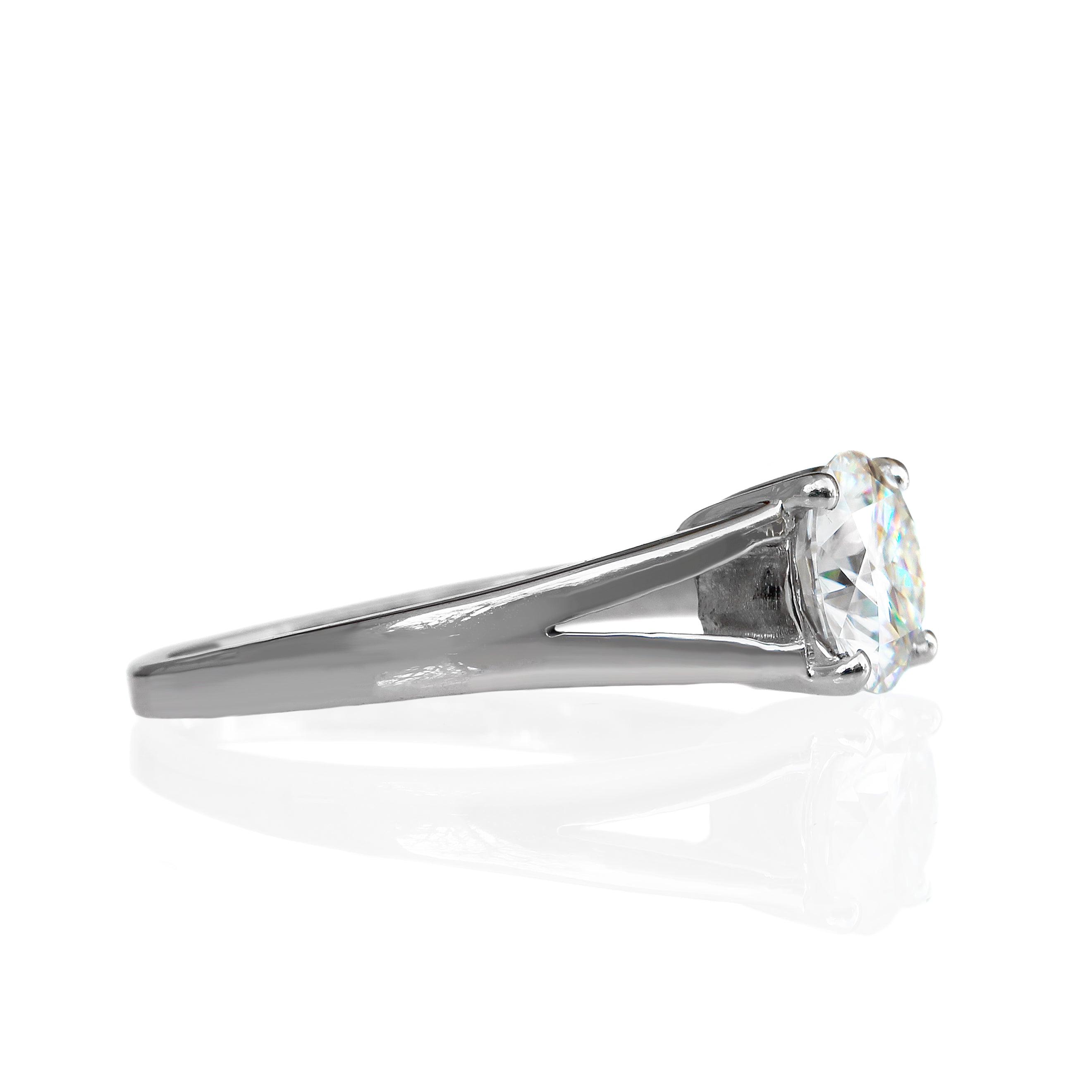 A product photo of an dazzling white moissanite solitaire ring in solid 925 sterling silver on a white background. The band is split into two prongs, meeting on either side of the 7mm round faceted jewel.