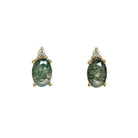 A product photo of a simple pair of stunning moss agate and diamond earrings set in solid 9ct yellow gold, with each 7x5mm moss agate gemstone topped by a trio of brilliant white diamonds.