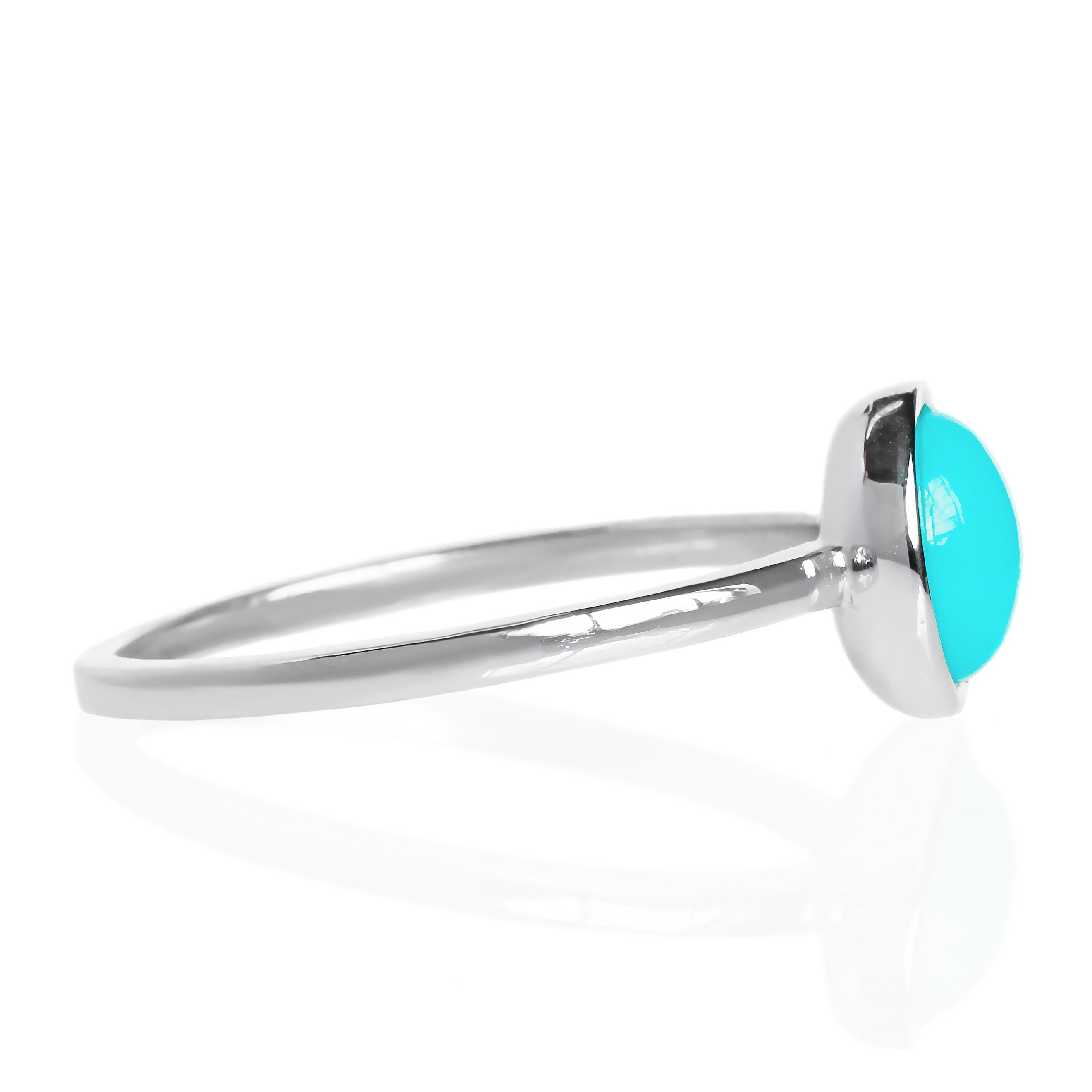 A product photo of a turquoise silver solitaire ring on a white background. The ring consists of a singular 7mm round cabochon-cut gem encased in a layer of silver bezel setting. The blue turquoise stone hails straight from the Sleeping Beauty mountains of Arizona. The band is simple and smooth silver metal. 