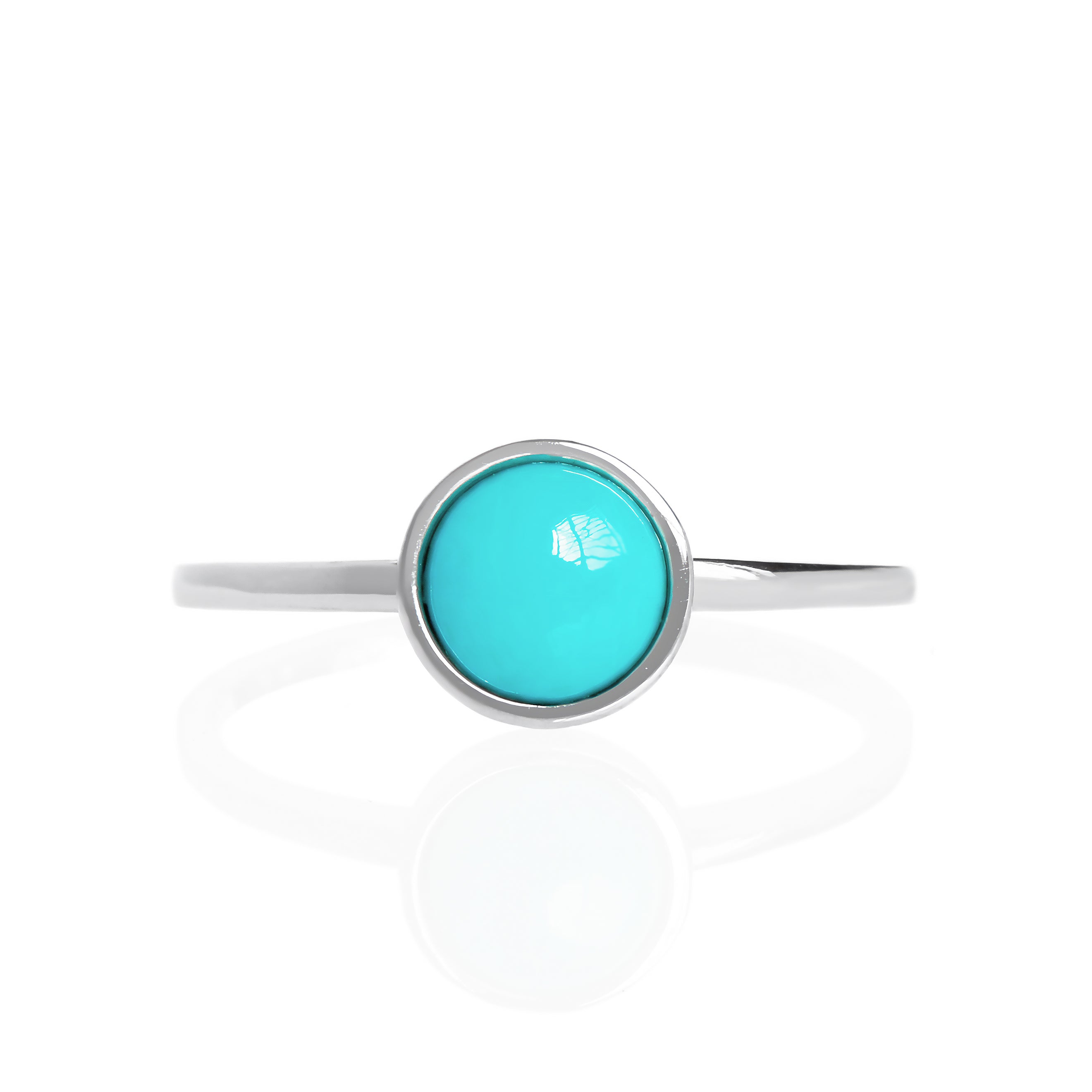 A product photo of a turquoise silver solitaire ring on a white background. The ring consists of a singular 6mm round cabochon-cut gem encased in a layer of silver bezel setting. The blue turquoise stone hails straight from the Sleeping Beauty mountains of Arizona. The band is simple and smooth silver metal. 