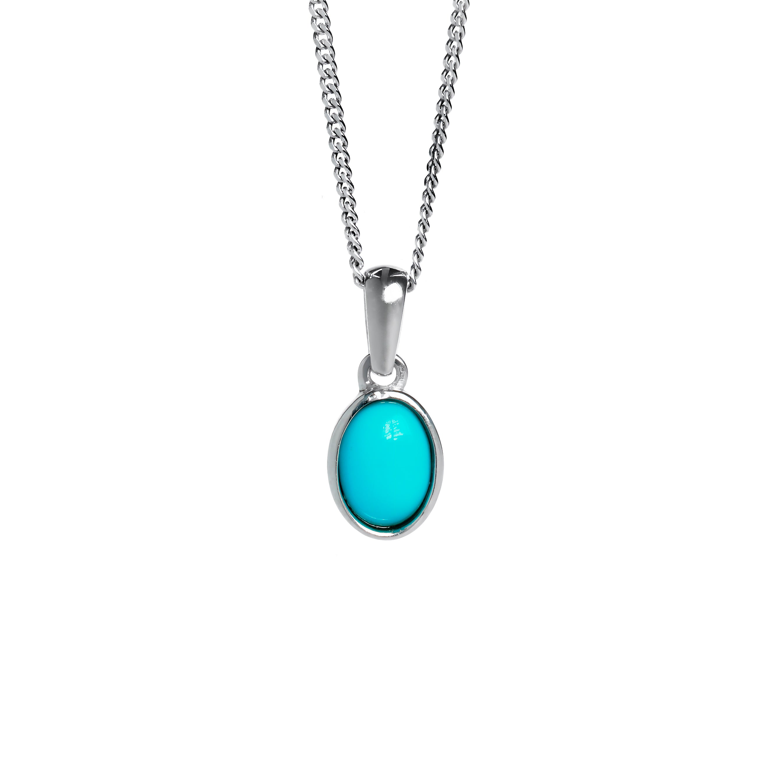 A product photo of a turquoise silver pendant suspended by a silver chain over a white background. The pendant consists of a singular 7x5mm oval cabochon-cut gem encased in a layer of silver bezel setting. The blue turquoise stone hails straight from the Sleeping Beauty mountains of Arizona. 