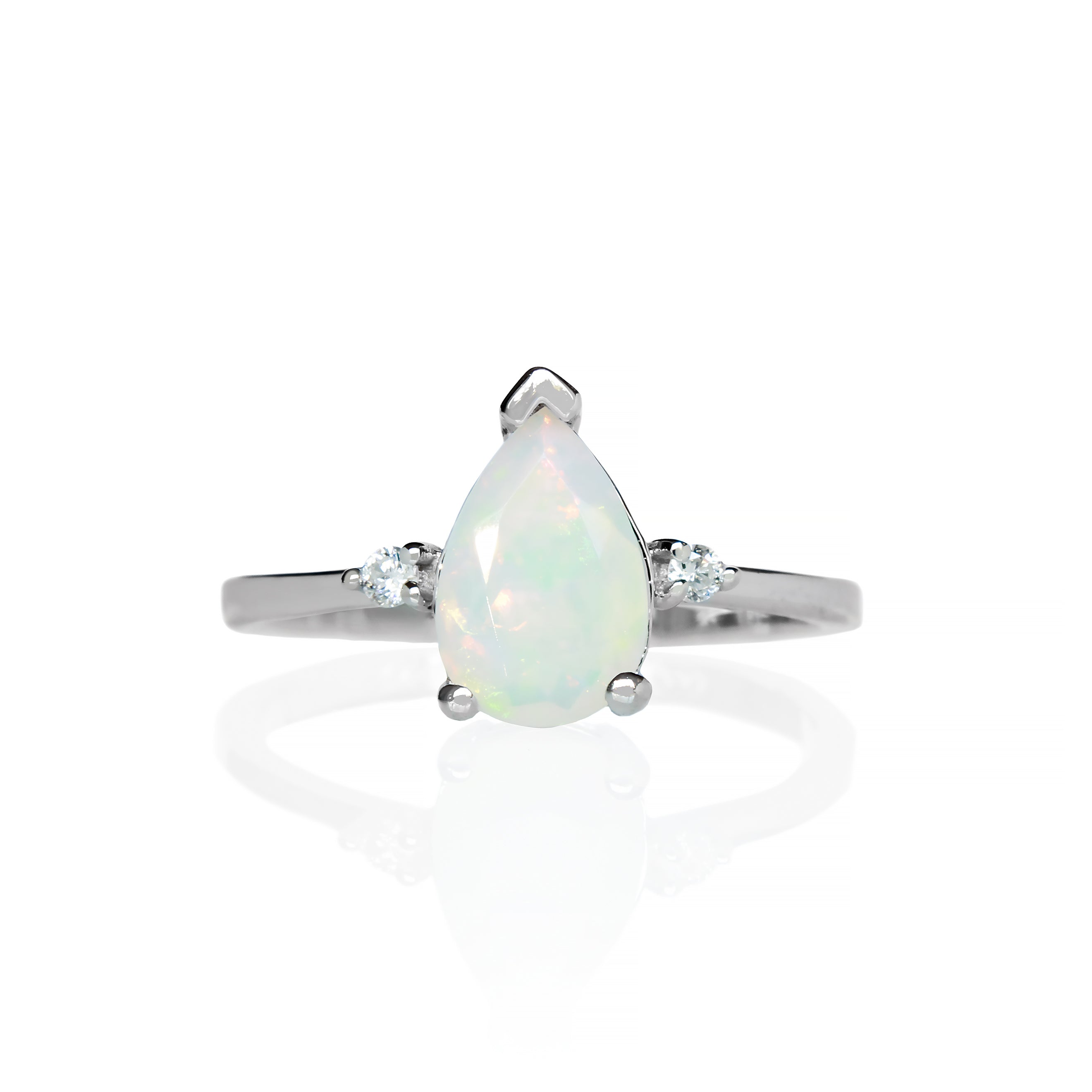 A product photo of a 9 karat white gold ring with a pear-cut rainbow opal centre stone sitting on a white background. The golden band is simple and smooth, meeting elegantly on either side of the centre stone, hugged by a single white diamond on either side.