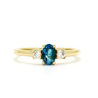 A dainty and elegant golden ring with a stunning trio of topaz and diamonds.