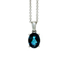 A product photo of a white gold london blue topaz pendant sitting against a white background. The impressively large and deeply-coloured oval-cut stone is contrasted by its overall minimalistic design, 4 simple white gold claws hold the gem in place. It is suspended by a simple white gold chain.