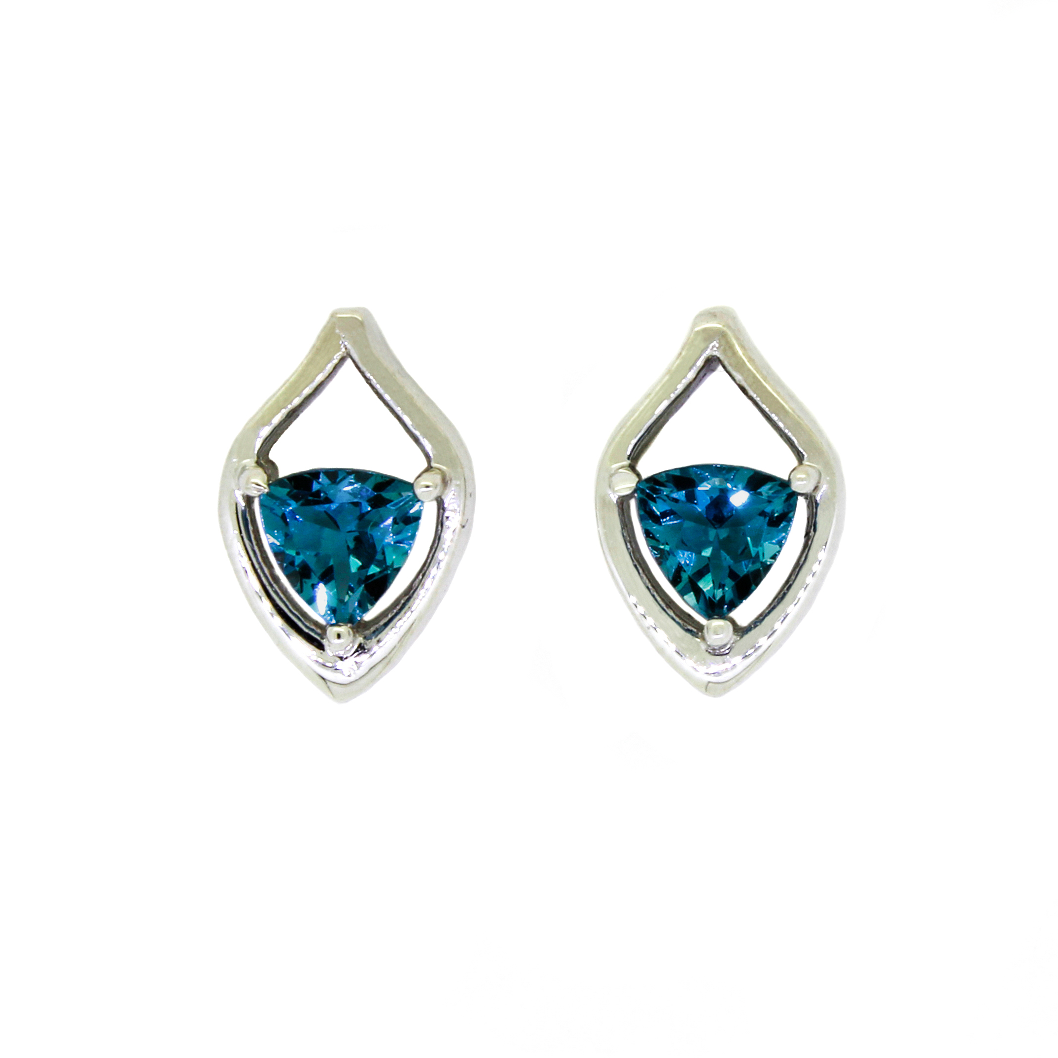 A product photo of a pair of white gold london blue topaz earrings sitting against a white background. The pair of trilliant topaz stones rest at the bottom of tear-shaped white gold frames.