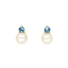 A product photo of delicate white pearl earring studs on a white background. The rosaline pearls each have aquamarine detailing above them connecting to the white gold studs.