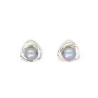 A product photo of a ornate steel grey pearl earring studs with detailed white gold backs on a white background.