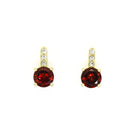 A product photo of 5mm Round Garnet & Diamond Earrings in 9k Yellow Gold sitting on a plain white background. A golden strip connects the garnets to the studs, each strip adorned with 3 diamonds each. The garnets reflect sanguine hues across their multi-faceted edges.