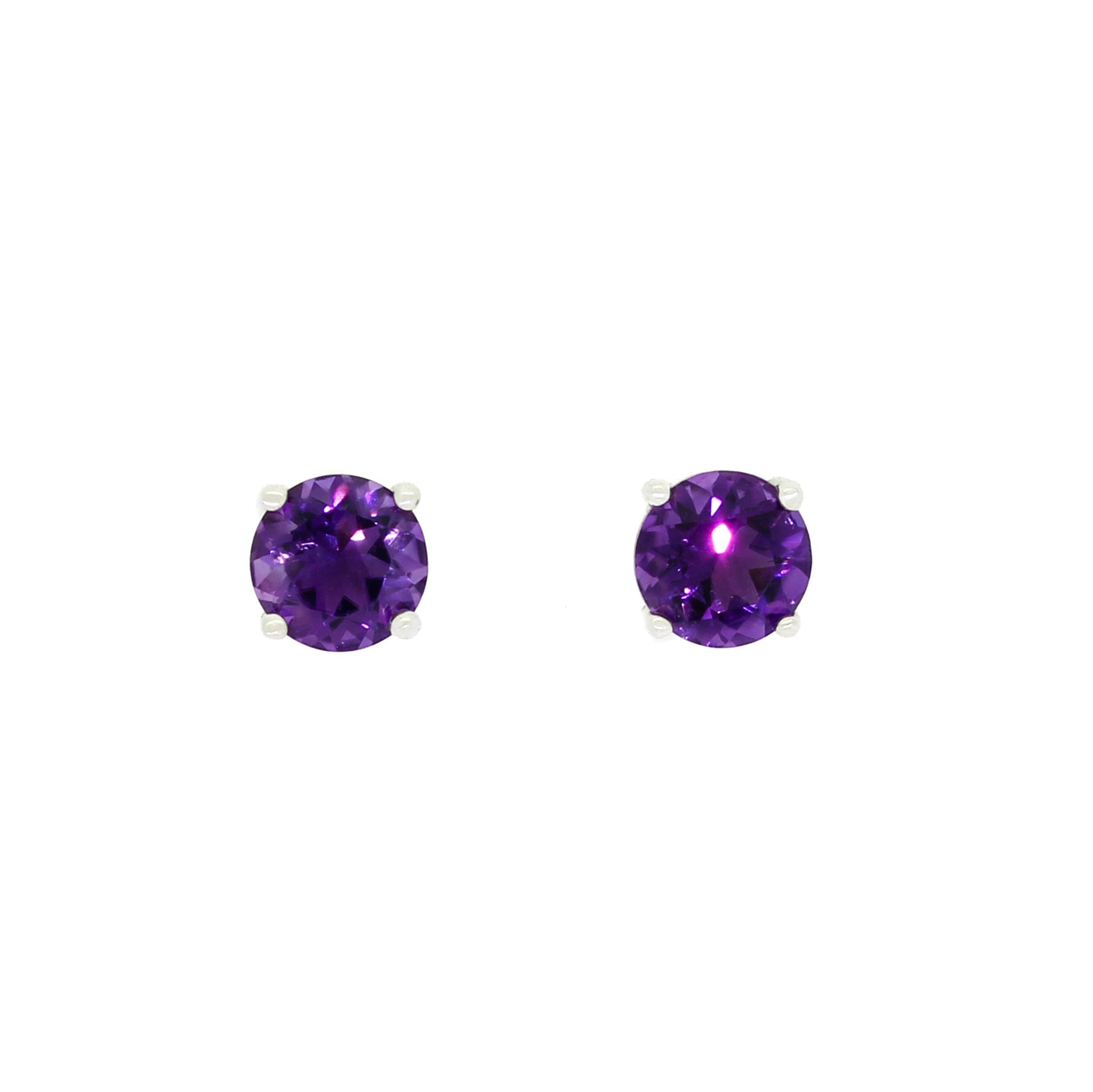 A product photo of two silver stud earrings sitting on a white background. Held in place by 4 silver claws each are two dazzling round-cut amethysts, reflecting violet and plum light from their many edges.