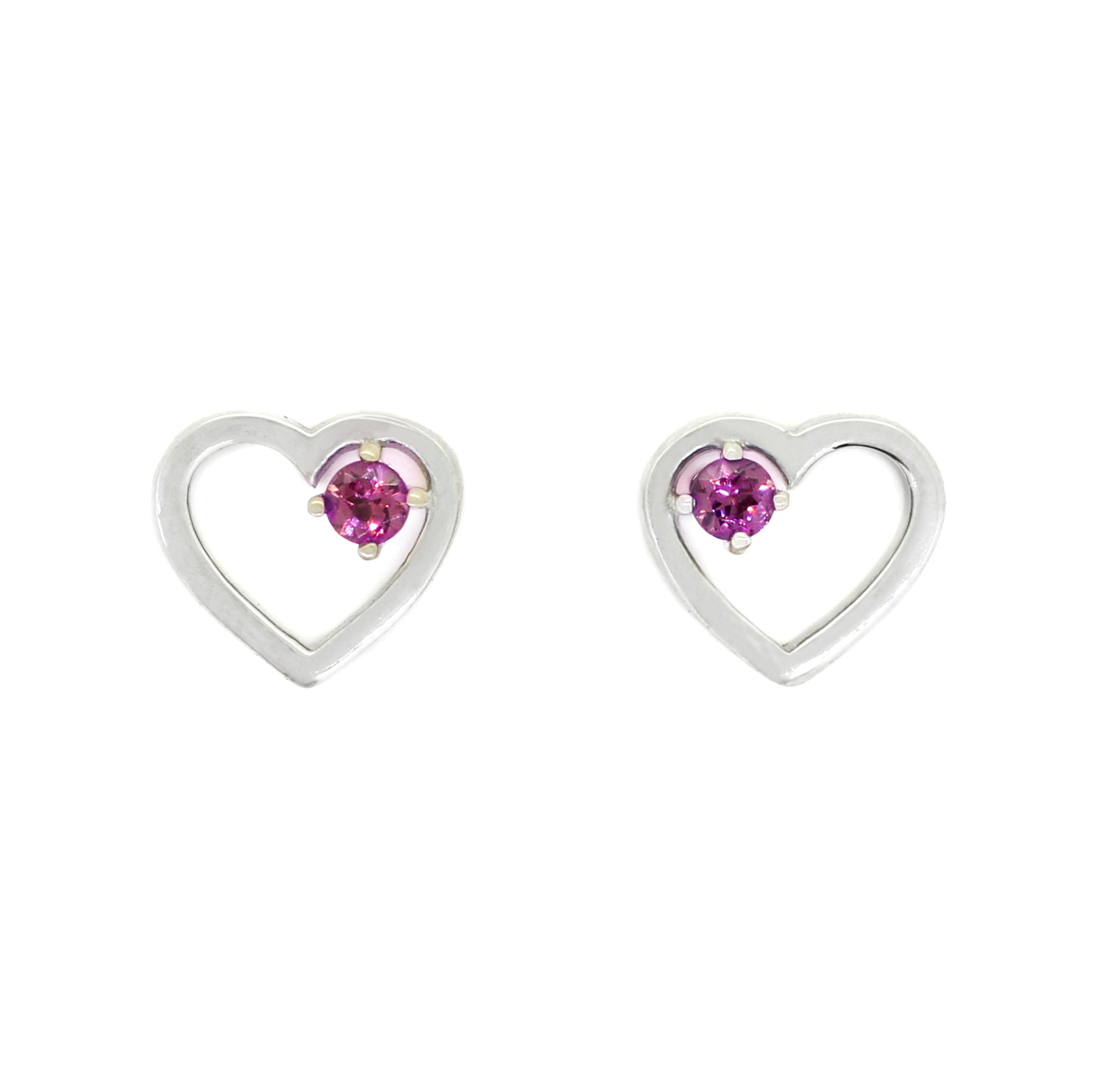 A product photo of two silver heart-shaped stud earrings sitting on a white background. A delicate, 2.5mm round warm purple rhodalite stone is nestled in the top right corner of each heart-shaped frame.