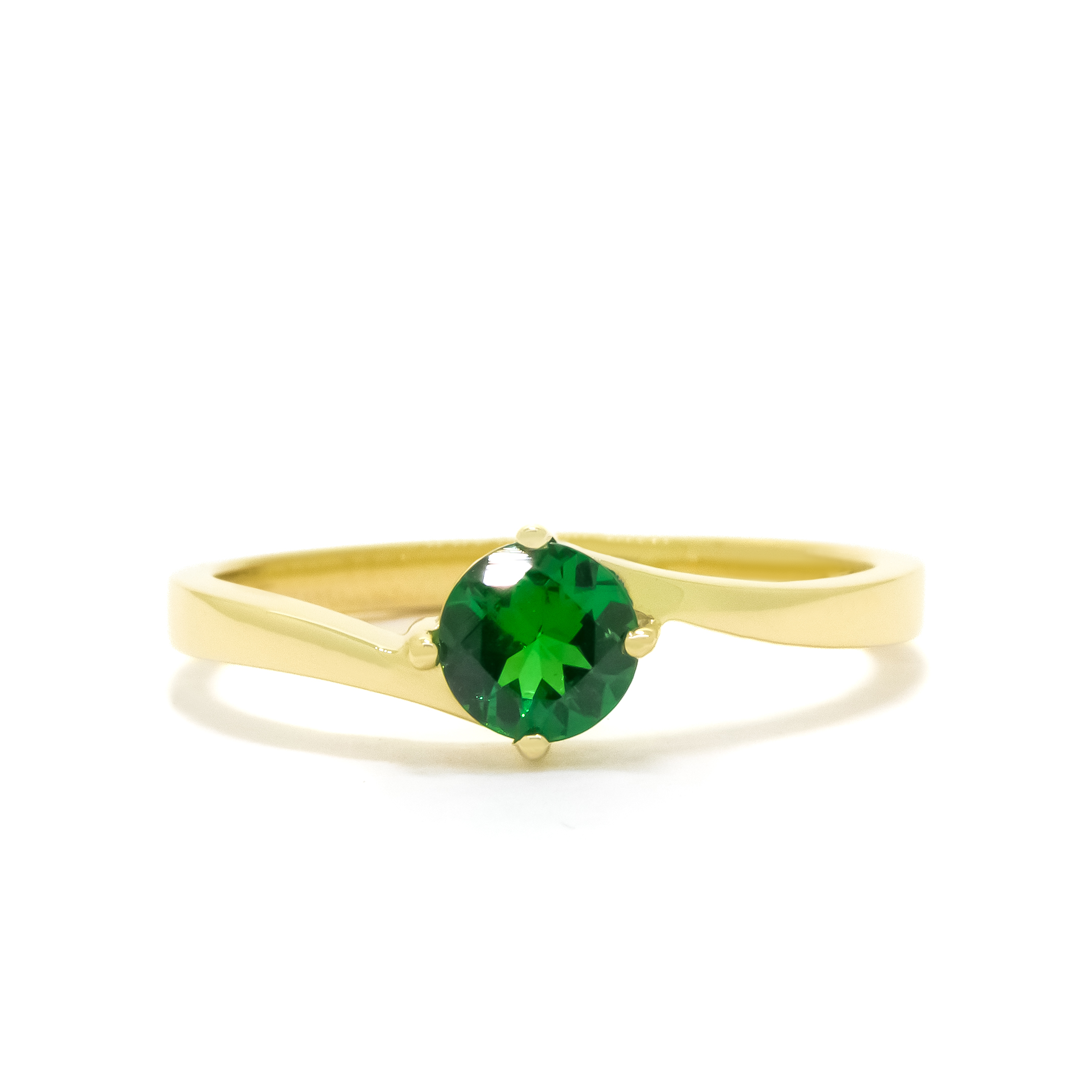 A product photo of a curved-band 9k yellow gold solitaire ring with a verdant-green tsavorite centre stone sitting on a white background. The green gemstone colour be a good emerald substitute.