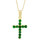 A product photo of a dainty cross pendant delicately bejewelled with electric green tsavorite stones suspended against a white background. The Christian cross pendant is made up of 11 stones in total, which reflect verdant hues from their facets.