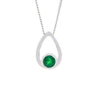 A product photo of a white gold pendant with a single, tiny emerald stone encased in white gold suspended against a white background. The bezel-set emerald sits at the bottom of a golden frame, shaped like a teardrop.