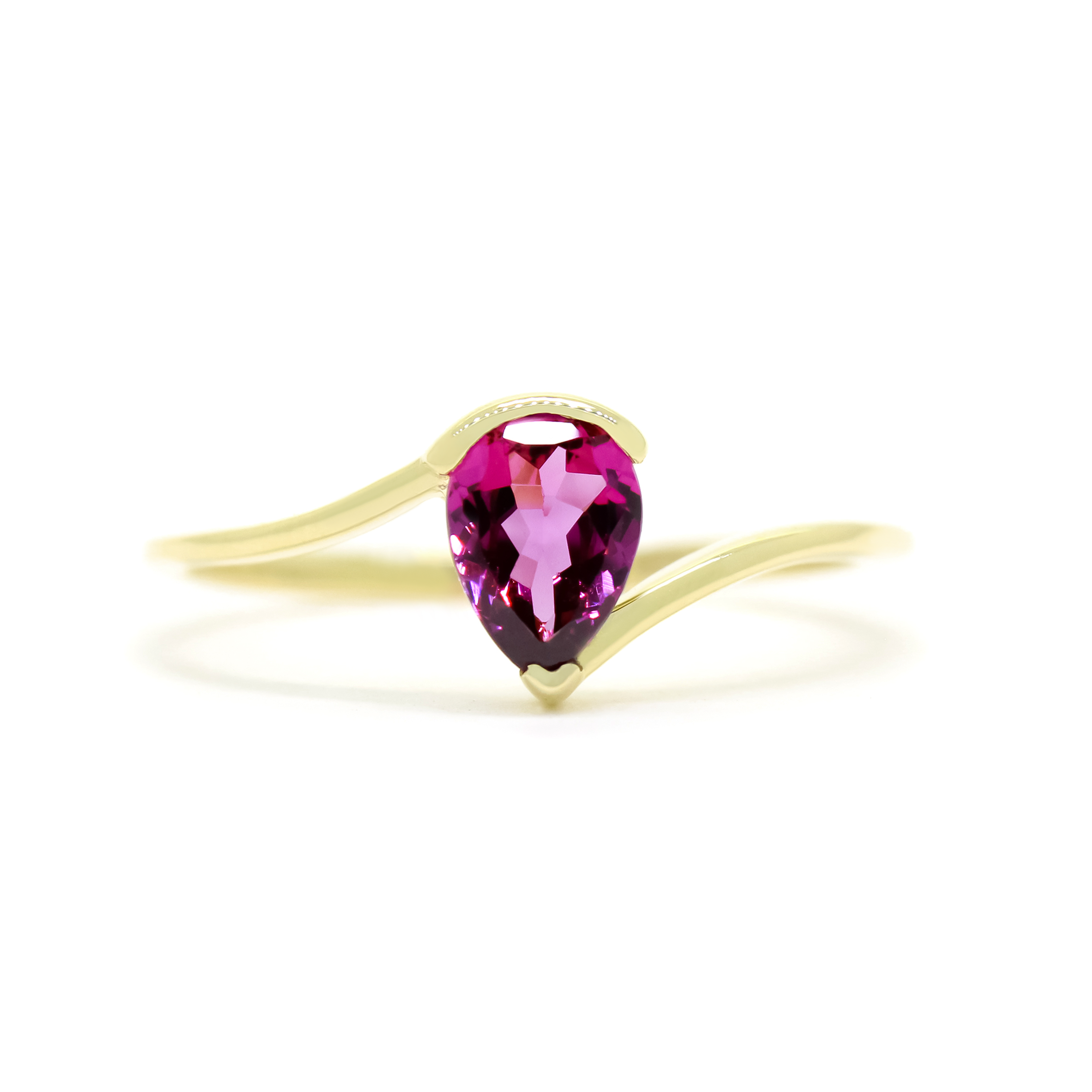 A product photo of a yellow gold grape garnet ring sitting against a white background. The gold band is plain and smooth, and curves to meet at the top and bottom of a large, 7x5mm pear shaped grape garnet centre stone - holding it in place.