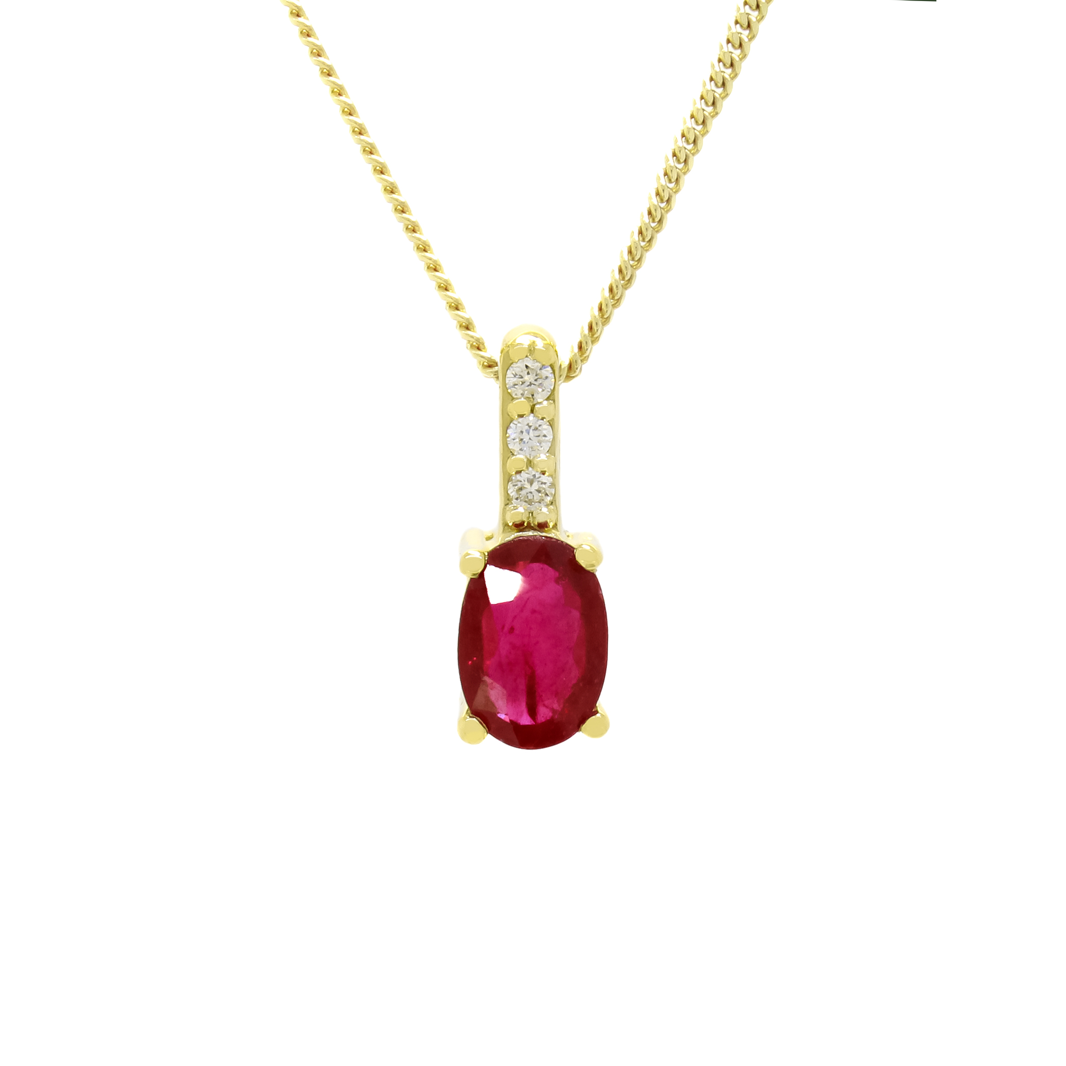 A product photo of a yellow gold ruby pendant suspended against a white background. The simple oval-cut stone is contrasted by the white diamond trio protruding in a straight line above the magenta ruby, encased in yellow gold.