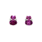 A product photo of a pair of white gold grape garnet earrings sitting against a white background. One smaller purple gemstone oval is stacked upon a larger oval on each earring, with the area where the two stones make contact decorated by a single small diamond on either side.