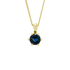 A product photo of a 5mm Round Fine blue Sapphire Pendant in 9ct Yellow Gold suspended against a white background. The stone is held in place by 6 delicate golden claws. It is suspended by a simple gold chain. The sapphire reflects deep ocean blue hues across its multi-faceted edges.