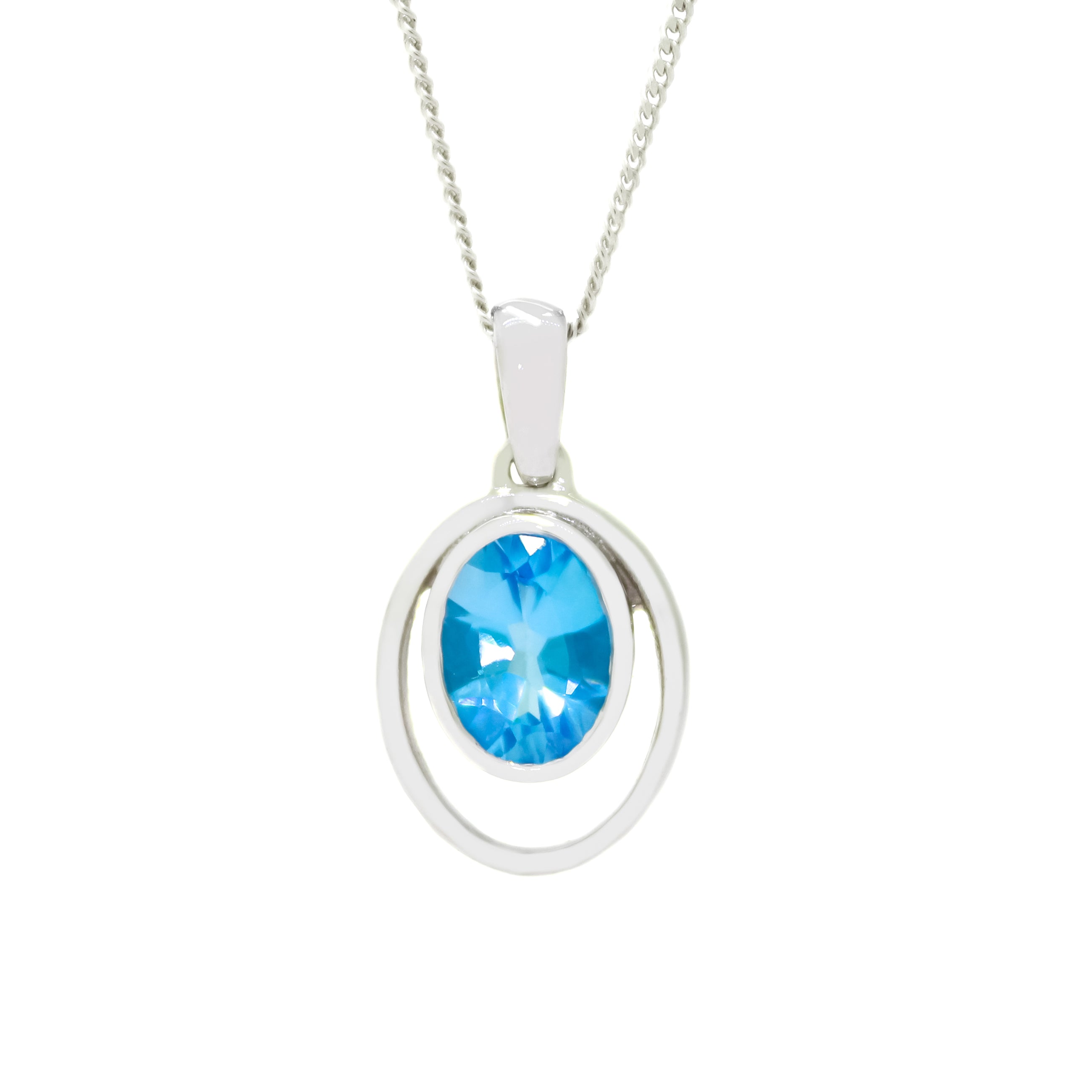 A product photo of a 5.5mm Round Bezel-set Blue Topaz necklace in 9ct White Gold sitting on a plain white background. The bezel-set stone is nestled at the bottom of golden oval loops of similar thickness to the bezel frames. The topaz jewel reflects tropical blue hues across their multi-faceted edges.