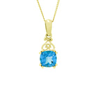 A product photo of a solid 9ct yellow gold necklace with a stunning bright blue topaz centre stone suspended over a white background. The blue topaz is cut in the shape of a square cushion, and is connected to the bail by mirrored, curling golden detailing, almost mimicking an inverted heart.