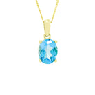 A product photo of a 9x7mm Oval blue topaz necklace in 9k yellow Gold suspended against a white background. The impressively large and deeply-coloured oval-cut stone is contrasted by its overall minimalistic design, 4 simple golden claws holding the gem in place. It is suspended by a simple gold chain. The stone is bright blue, reflecting tropical sky blue hues across its multi-faceted edges.