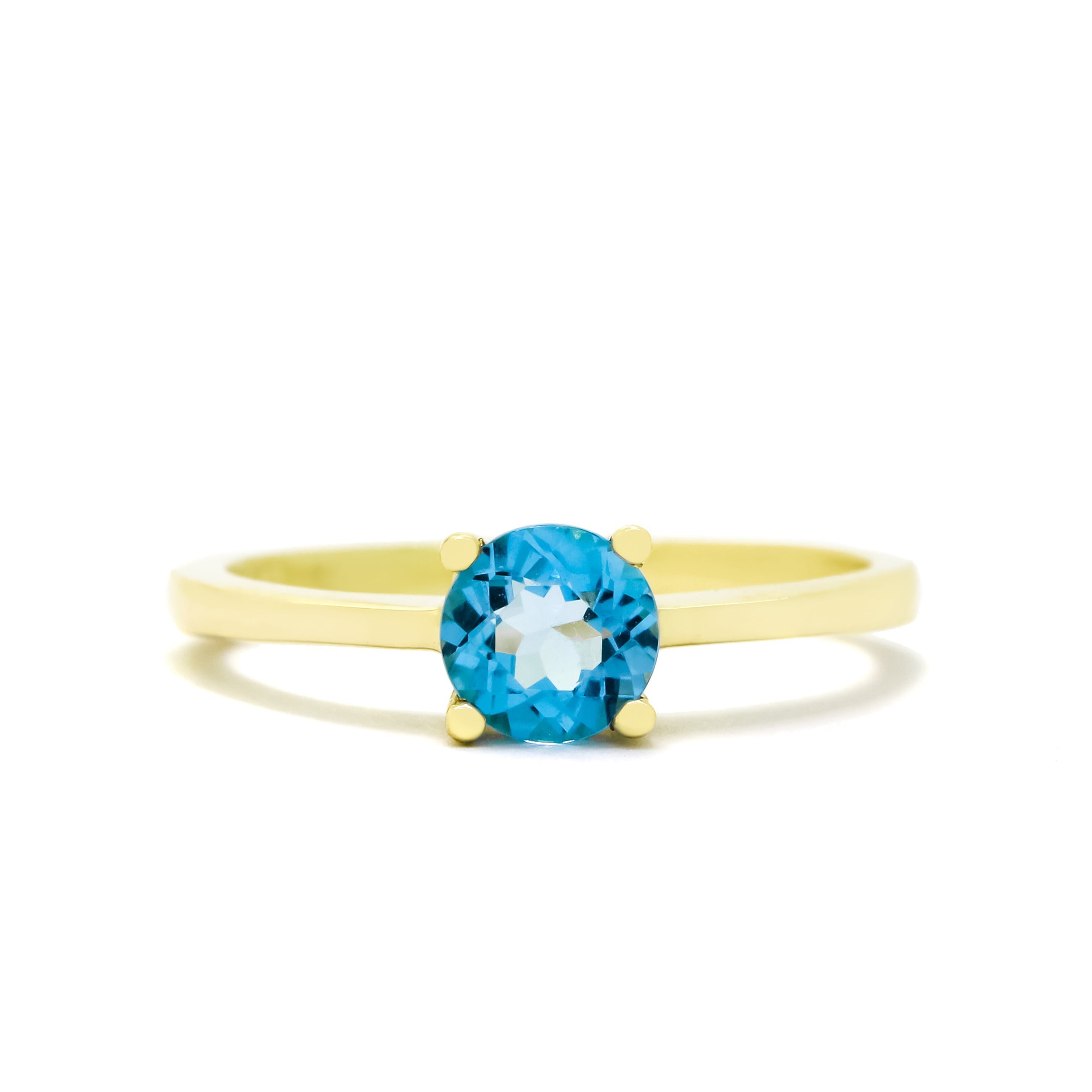 A product photo of a Round blue topaz Solitaire Ring in 9k Yellow Gold sitting on a plain white background. The topaz centrestone measures 5.5mm across. The stone is a bright, sky blue colour, reflecting tropical ocean light across its many faceted edges.