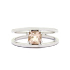 A product photo of a split-band white gold ring with a claw-set morganite centre stone sitting on a white background. The band splits at the base of the ring, separating to meet at the top and bottom of the pale pink cushion-cut centre stone, held in place by 2 tiny claws on each corner.