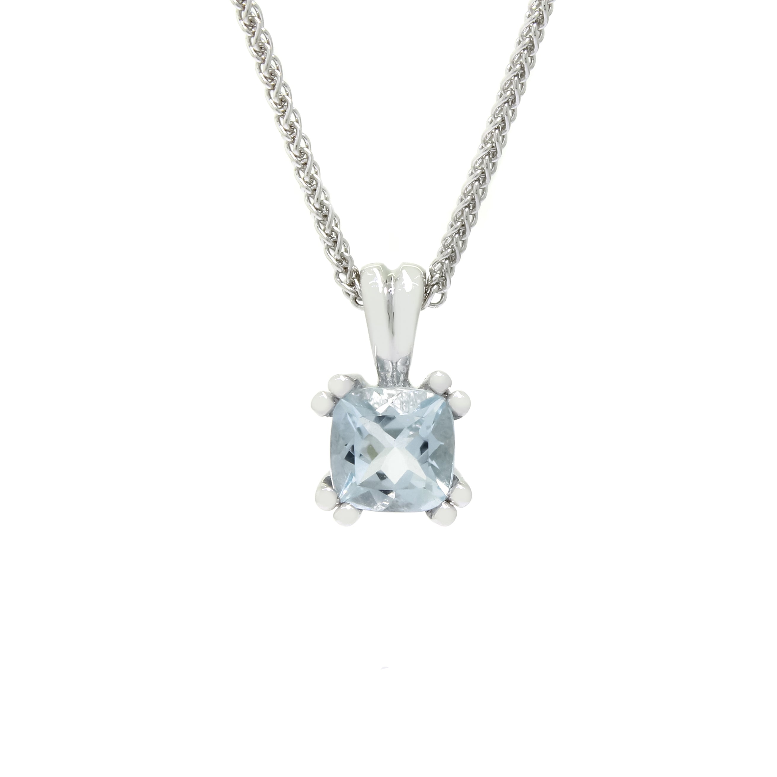 A product photo of a white gold aquamarine pendant suspended by a chain against a white background. The squared cushion-cut stone is held in place by 2 small claws on each corner to a total of 8, and reflects pale baby blue colours from its many edges.