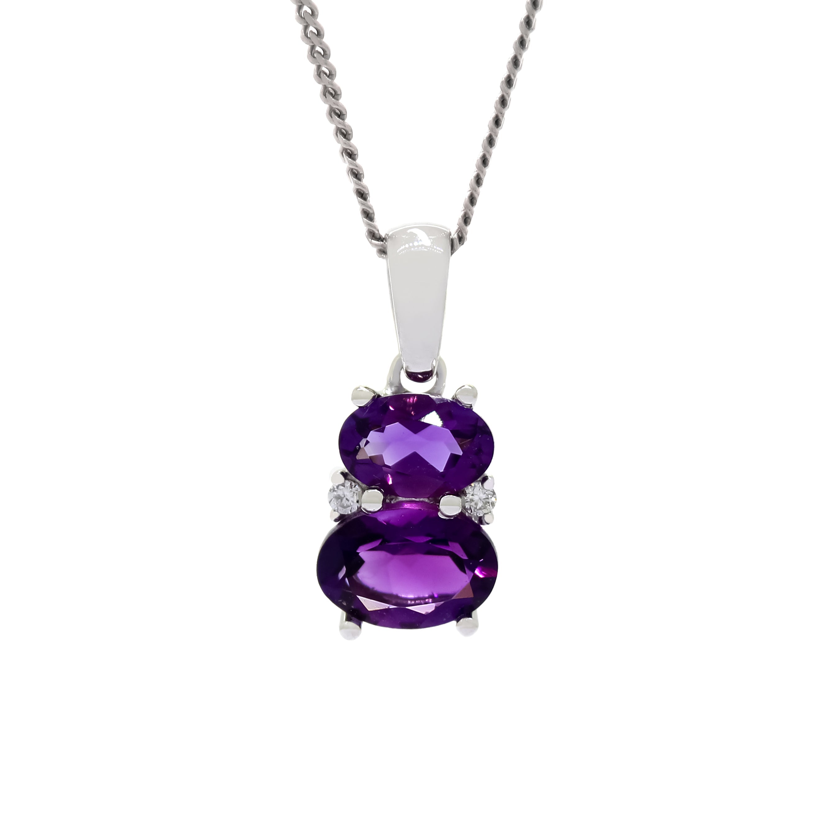 A product photo of an amethyst and diamond pendant in 9k white gold sitting on a white background. The pendant is made up of two horizontal oval-shaped purple amethyst gemstones, the bottom one being 7x5mm and the top being 6x4mm. The spaces between the two stones are filled with one small diamond on either side.