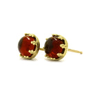 A product photo of a bold, ornate pair of fiery garnet earrings set in solid 9ct yellow gold. The cabochon shaped red garnet gemstones sit in elaborately detailed yellow gold earring settings, almost designed to look like an antique crown.