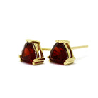 A product photo of 9ct yellow gold garnet stud earrings sitting on a white background. The trilliant stones are held in place by two claws on each corner, to a total of 6. The deep red garnet stones reflect sanguine light from their many edges.