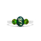 A product photo of a dainty and elegant white gold ring with a stunning trio of moss agate and green tourmaline sitting against a white background. The largest of the stones sits in the centre, an oval 6x4mm moss agate with stunning vine-like natural inclusions - hugged by two smaller circular warm green tourmaline stones on either side.