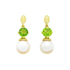 This product image features a pair of solid yellow gold gemstone and pearl earrings with a unique design. The main components are two chartreuse green peridot gems, each one set above a single rounded white pearl.