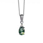 A product photo of a white gold moss agate and diamond necklace sitting against a white background. The beautifully unique moss agate stone is held in place by 4 pairs of claws at its top and bottom, with a trio of white diamonds connecting the stone to the rest of the pendant. It is suspended by a simple white gold chain.