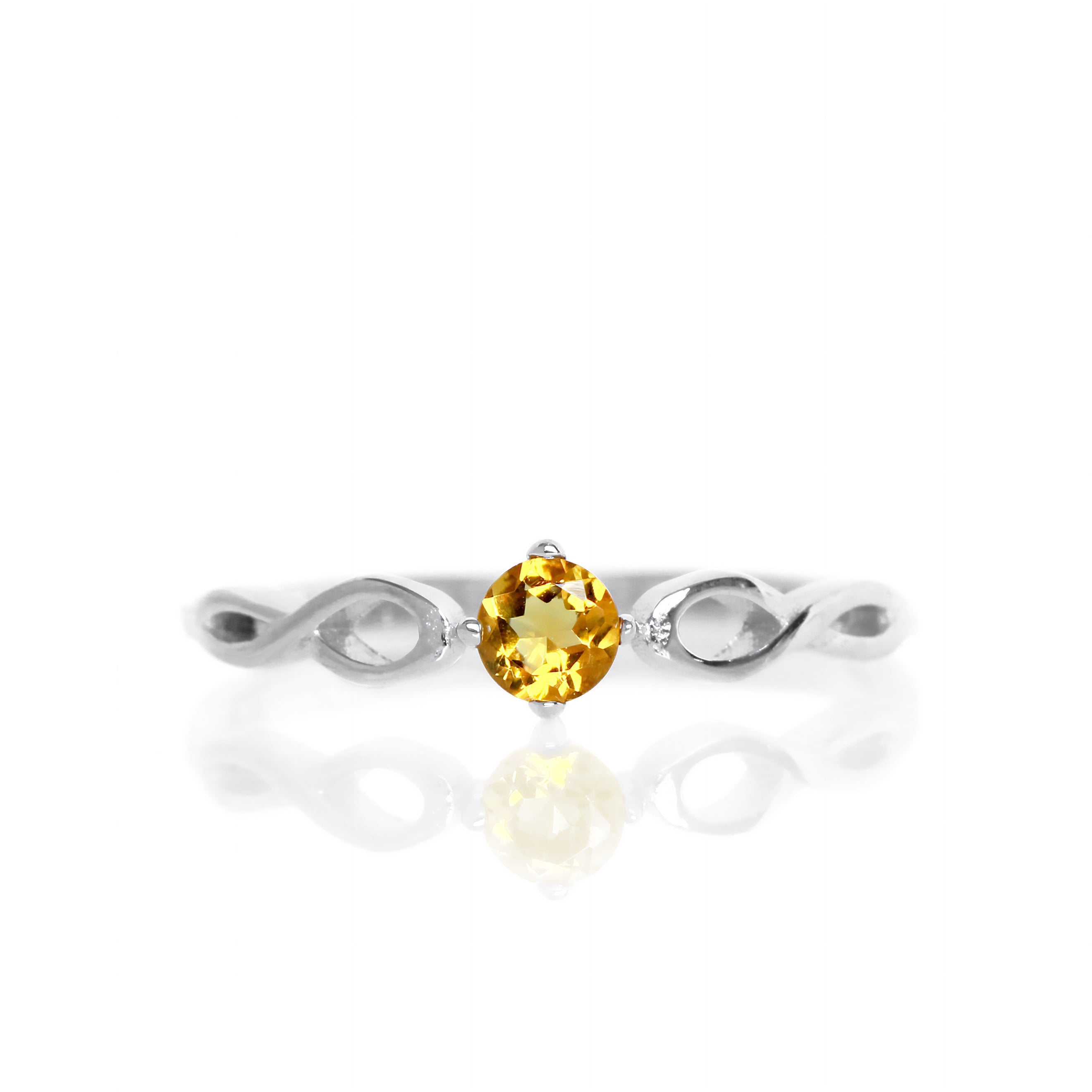 A product photo of an ornate silver ring with a citrine centre stone sitting on a white background. The silver band splits halfway along its length, becoming twisting and serpentine in appearance before meeting on either side of the dazzling orange 3.5mm stone, which is held in place by 4 silver claws.