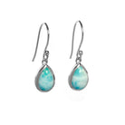 A product photo of a pair of sterling silver Larimar drop earrings suspended against a white background. The drop earrings feature shepherd hooks, and the 9x6mm pear-shaped cabochon Larimars are held in place by silver bezel settings.